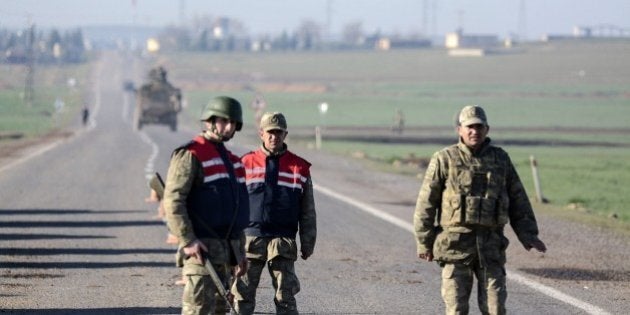 Turkish army soldiers take position on the road to the Mursitpinar crossing gate near the Syrian border on February 22, 2015 in Suruc, Sanliurfa province, during an operation to relieve the garrison guarding the Suleyman Shah mausoleum in northern Syria. The operation was jointly conducted by the intelligence organisation and the Turkish army, a few days after reports suggested that the tomb was besieged by jihadists belonging to the Islamic State (IS) group. AFP PHOTO/ILYAS AKENGIN (Photo credit should read ILYAS AKENGIN/AFP/Getty Images)