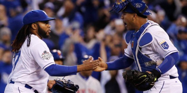 Kansas City Royals catcher Salvador Perez, right, congratulates starting pitcher Johnny Cueto at the end of Game 2 of the Major League Baseball World Series against the New York Mets Wednesday, Oct. 28, 2015, in Kansas City, Mo. The Royals defeated the Mets 7-1 to take at two game lead in the series. (AP Photo/Matt Slocum)
