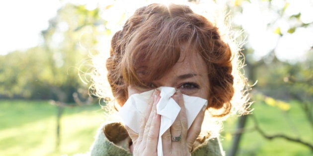 Redheaded woman blowing her nose