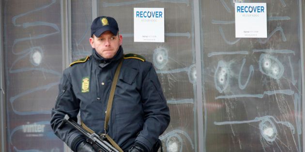 A police officer stands in front of the cultural center where an alleged shooter killed one person on Saturday in Copenhagen, Denmark, Monday, Feb. 16, 2015. The shooter was killed by police who believe he also shot a second person at a Jewish synagogue. (AP Photo/Michael Probst).
