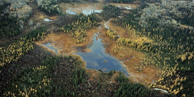 Aerial view of a lake and forests in the vicinity of oil sands extraction facilities near the town of Fort McMurray in Alberta Province, Canada on October 23, 2009. Greenpeace are calling for an end to oil sands mining in the region due to their greenhouse gas emissions and have recently staged sit-ins which briefly halted production at several mines. At an estimated 175 billion barrels, Alberta's oil sands are the second largest oil reserve in the world behind Saudi Arabia, but they were neglected for years, except by local companies, because of high extraction costs. Since 2000, skyrocketing crude oil prices and improved extraction methods have made exploitation more economical, and have lured several multinational oil companies to mine the sands. AFP PHOTO/Mark RALSTON (Photo credit should read MARK RALSTON/AFP/Getty Images)