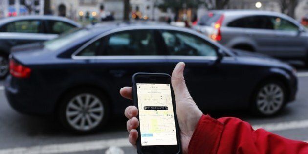 An UBER application is shown as cars drive by in Washington, DC on March 25, 2015. Uber said it was ramping up safety in response to rape allegations against a driver in India and growing concerns about background checks for operators of the popular ride-sharing service. In other cities where Uber operates, critics had complained that a lack of licensing and background checks of drivers could imperil those who use the service. AFP PHOTO/ ANDREW CABALLERO-REYNOLDS (Photo credit should read Andrew Caballero-Reynolds/AFP/Getty Images)