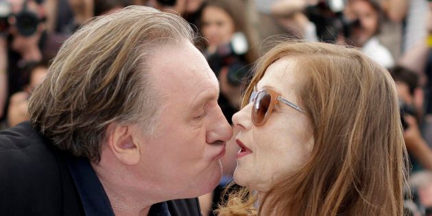 Actor Gerard Depardieu, left, tries to kiss actress Isabelle Huppert during a photo call for the film Valley of Love, at the 68th international film festival, Cannes, southern France, Friday, May 22, 2015. (AP Photo/Thibault Camus)