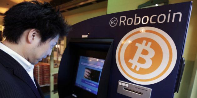 Customer Kiyono Yuichi purchases bitcoins from the BMEX bitcoin exchange's Robocoin-branded automated teller machine (ATM) at The Pink Cow restaurant and bar in Tokyo, Japan, on Wednesday, June 18, 2014. Bitcoin, proposed by an anonymous programmer or programmers in 2008, has drawn entrepreneurs and retailers looking to popularize it as a low-cost alternative to established payment systems, supplanting credit cards to international wire transfers. Photographer: Yuriko Nakao/Bloomberg via Getty Images
