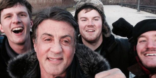 In this Jan. 17, 2015, photo provided by Peter Rowe, Rowe, right, takes a selfie with friends Jacob Kerstan, left, Andrew Wright, third from left and actor Sylvester Stallone in Philadelphia. Rowe said the three friends had just finished racing up the staircase at the city's Museum of Art when they saw Stallone. Stallone made the steps famous in his first turn as fictional boxer Rocky Balboa, who used them as part of his training regimen. Thousands of people now visit the steps each year to re-create the run. (AP Photo/Peter Rowe)