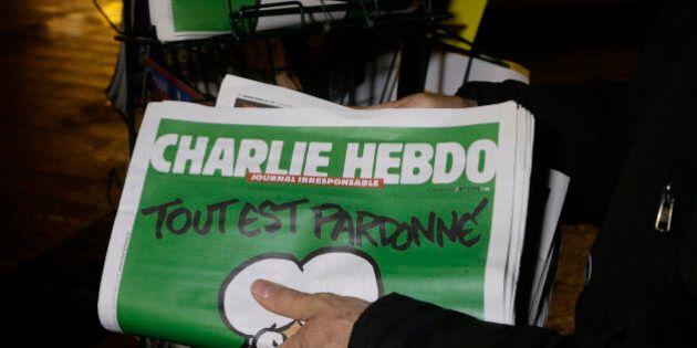A seller of newspapers installs in shelf, several Charlie Hebdo newspapers at a newsstand in Nice southeastern France, Wednesday, Jan. 14, 2015. On front page reading