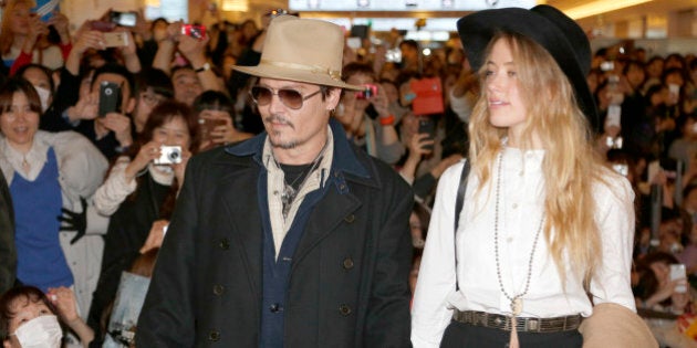 U.S. actor Johnny Depp and his fiancee Amber Heard arrive at Haneda international airport in Tokyo Monday, Jan. 26, 2015 for his latest film