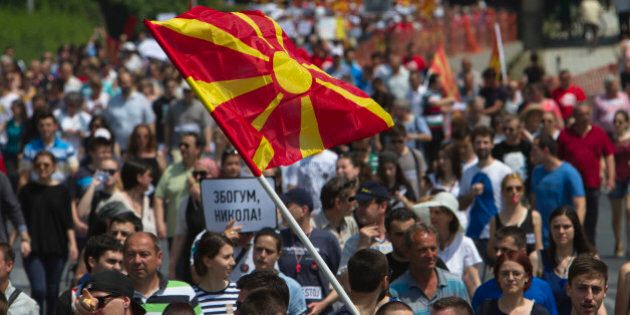 Protesters holding a Macedonian flag and banners reading
