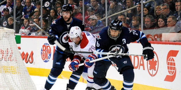 WINNIPEG, CANADA - MARCH 26: Andrei Markov #79 of the Montreal Canadiens tries to break through a check by Drew Stafford #12 and Blake Wheeler #26 of the Winnipeg Jets as they chase the loose puck during first period action on March 26, 2015 at the MTS Centre in Winnipeg, Manitoba, Canada. (Photo by Lance Thomson/NHLI via Getty Images)