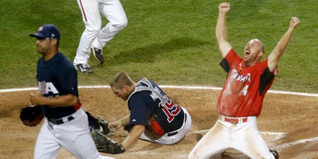Canada's Peter Orr, right, scores the game-winning run under the tag of United States catcher Thomas Murphy's in the 10th inning of the gold medal baseball game at the Pan Am Games, Sunday, July 19, 2015, in Ajax, Ontario. (AP Photo/Julio Cortez)
