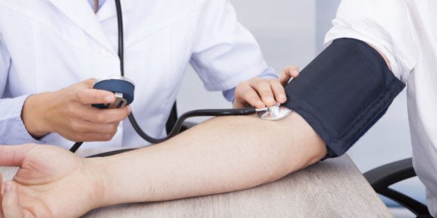 Close-up Of Female Doctor's Hand Checking Blood Pressure