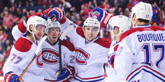 CALGARY, AB - OCTOBER 28: Tom Gilbert #77 (L) of the Montreal Canadiens celebrates with his teammates after scoring against the Calgary Flames during an NHL game at Scotiabank Saddledome on October 28, 2014 in Calgary, Alberta, Canada. (Photo by Derek Leung/Getty Images)