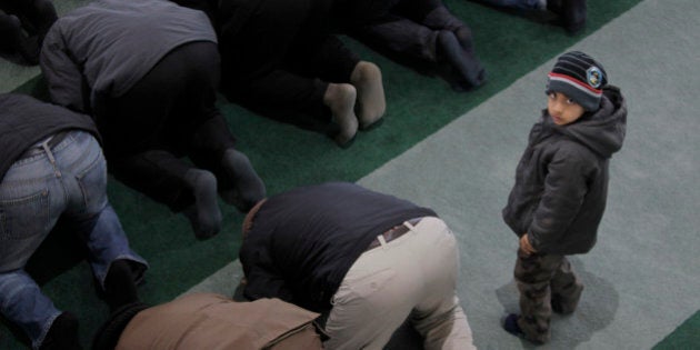 A boy looks up as worshippers from the Ahmadiyya Muslim community attend Friday prayers at the Baitul Futuh Mosque in south London, Friday, Feb. 18 18, 2011. According to the community, a sect of Islam that is represented in more than180 countries, the mosque is the largest in western Europe. (AP Photo/Lefteris Pitarakis)