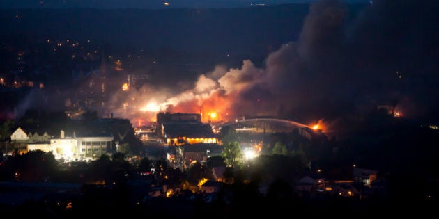 Firefighters douse blazes after a freight train loaded with oil derailed in Lac-Megantic in Canada's Quebec province on July 6, 2013, sparking explosions that engulfed about 30 buildings in fire. At least 80 people are missing after a driverless oil tanker train derailed and exploded in the small Canadian town of Lac-Megantic, destroying dozens of buildings, a firefighter back from the scene told AFP. AFP PHOTO / François Laplante-Delagrave (Photo credit should read François Laplante-Delagrave/AFP/Getty Images)