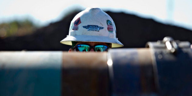 A Michels Corp. contractor watches as two sections of pipe are prepped for welding during construction of the Flanagan South crude oil pipeline outside Goodfield, Illinois, U.S., on Tuesday, Oct. 8, 2013. The approximately 600-mile, 36-inch crude oil pipeline is being constructed by Enbridge Energy Co., a subsidiary of Enbridge Inc., Canada's largest oil transporter, and will originate in Flanagan, Illinois and terminate in Cushing, Oklahoma. Photographer: Daniel Acker/Bloomberg via Getty Images