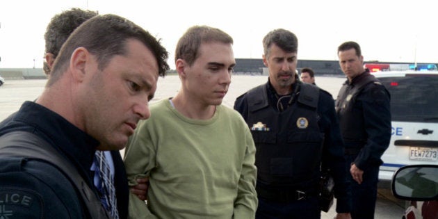 FILE - In this Monday, June 18, 2012 file photo provided by Montreal Police, Luka Rocco Magnotta is taken by police from a Canadian military plane to a waiting van in Mirabel, Quebec. Magnotta, a Canadian porn actor accused of dismembering his Chinese lover and mailing the body parts to political parties and schools collapsed in court during his preliminary hearing Tuesday, March 13, 2013. (AP Photo/Montreal Police, File)