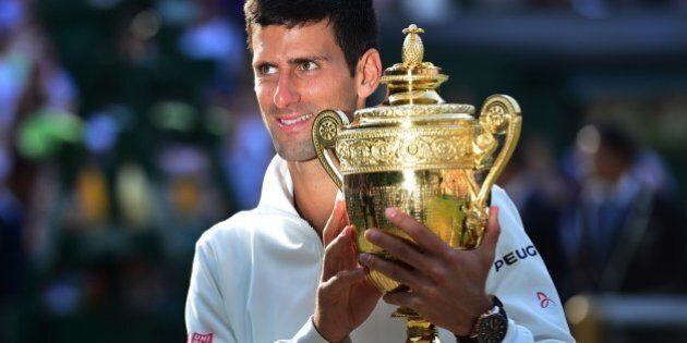 Serbia's Novak Djokovic holds the winner's trophy after beating Switzerland's Roger Federer in the men's singles final match during the presentation on day thirteen of the 2014 Wimbledon Championships at The All England Tennis Club in Wimbledon, southwest London, on July 6, 2014. Djokovic won his second Wimbledon title and seventh career major with a 6-7 (7/9), 6-4, 7-6 (7/4), 5-7, 6-4 victory over Roger Federer Sunday, shattering the Swiss star's dream of a record eighth triumph in a titanic struggle. AFP PHOTO / CARL COURT - RESTRICTED TO EDITORIAL USE (Photo credit should read CARL COURT/AFP/Getty Images)