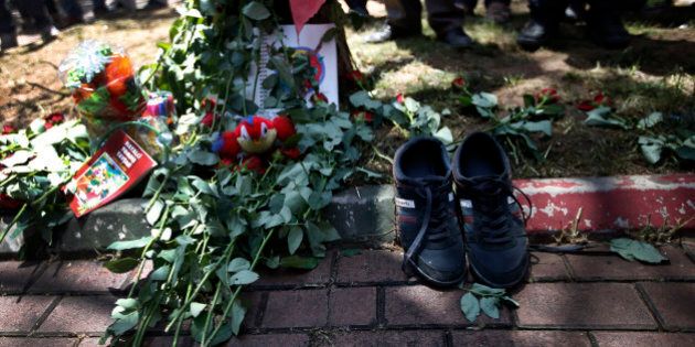 A pair of shoes belonging to a victim are seen next to flowers, laid down by mourners at the site of Monday's explosion in the Turkish town of Suruc near the Syrian border, Tuesday, July 21, 2015. Authorities suspected the Islamic State group was behind an apparent suicide bombing Monday in Suruc in southeastern Turkey that killed 31 people and wounded nearly 100 â a development that could represent a major expansion by the extremists at a time when the government is stepping up efforts against them. (AP Photo/Emrah Gurel)