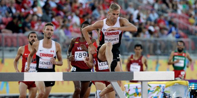 Canada's Matt Hughes jumps over a hurdle during the finals of the men's 3000 meter steeplechase at the Pan Am Games in Toronto, Tuesday, July 21, 2015. Hughes won the gold medal. (AP Photo/Mark Humphrey)