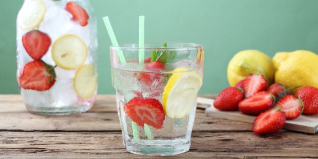 ice long drink strawberry and lemon in glass green background