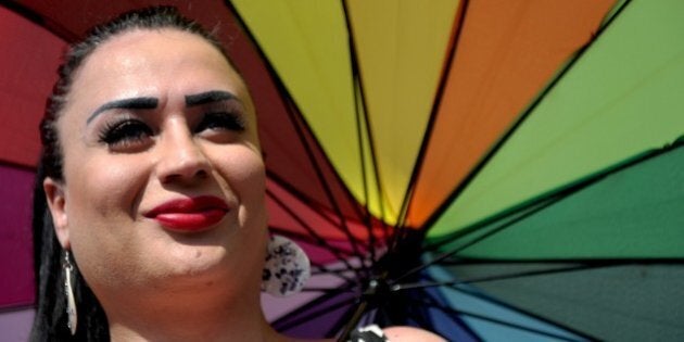 A transgender person looks on with an rainbow umbrella during a Gay Pride parade on June 28, 2015 in...