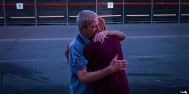 LAC-MEGANTIC, CANADA - JULY 14: Marcel Larrivee (L) comforts Patricia Landry after the pair first witnessed the aftermath of the destruction on July 14, 2013 in Lac-Megantic, Quebec, Canada. A train derailed and exploded into a massive fire that flattened dozens of buildings in the town's historic district, leaving 60 people dead or missing in the early morning hours of July 6. (Photo by Ian Willms/Getty Images)