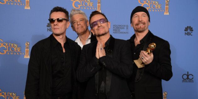 From left, Larry Mullen Jr., Adam Clayton, Bono and The Edge of U2 pose in the press room with the award for best original song for