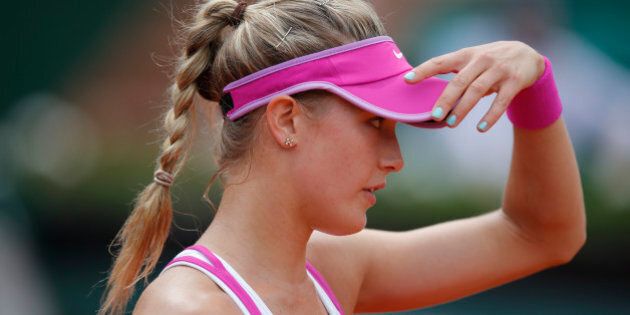 Canada's Eugenie Bouchard adjusts her cap as she plays France's Kristina Mladenovic during their first round match of the French Open tennis tournament at the Roland Garros stadium, Tuesday, May 26, 2015 in Paris. Mladenovic won 6-4, 6-4. (AP Photo/Francois Mori)