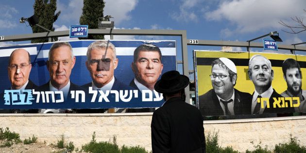 Un homme juif orthodoxe regarde l'affiche de la campagne électorale du parti Bleu-blanc, qui montre ses dirigeants, Benny Gantz, Yair Lapid, Moshe Yaalon et Gaby Ashkenazi, ainsi que le premier ministre israélien Benjamin Netanyahu aux côtés de membres du parti politique d'extrême droite israélien, le Foyer juif.