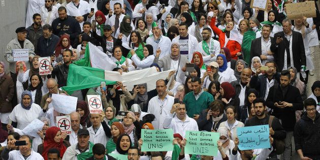 Des Algériens défilent avec des banderoles et des drapeaux lors d'une manifestation à Alger, en Algérie. Des milliers d'étudiants, de médecins, de dentistes et de vétérinaires ont défilé dans la capitale algérienne pour exiger la démission du président Abdelaziz Bouteflika.