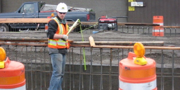 This worker is "measuring twice and cutting once." He's working on the new First Avenue S ramp from the Spokane Street Viaduct.