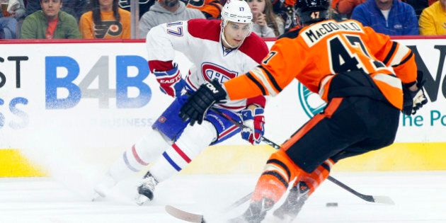 Montreal Canadiens' Rene Bourque, left, looks to make his move with the puck against Philadelphia Flyers' Andrew MacDonald, right, during the first period of an NHL hockey game, Saturday, Oct. 11, 2014, in Philadelphia. (AP Photo/Chris Szagola)