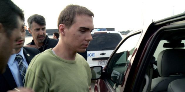 In this photo provided by Montreal Police, Luka Rocco Magnotta is taken by police from a Canadian military plane to a waiting van on Monday, June 18, 2012, in Mirabel, Quebec. Magnotta, the suspect in the killing and dismemberment of a Chinese student, returned to Canada via military transport from Germany, where he was arrested this month. (AP Photo/Montreal Police)