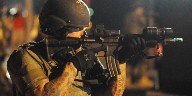 A law enforcement officer watches on during a protest on West Florissant Avenue in Ferguson, Missouri on August 18, 2014. Police fired tear gas in another night of unrest in a Missouri town where a white police officer shot and killed an unarmed black teenager, just hours after President Barack Obama called for calm. AFP PHOTO / Michael B. Thomas (Photo credit should read Michael B. Thomas/AFP/Getty Images)