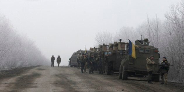 Ukrainian military convoy stop on the road between the towns of Dabeltseve and Artemivsk, Ukraine, Saturday, Feb. 14, 2015. The fighting between Russia-backed separatists and Ukrainian government forces has continued despite the agreement reached by leaders of Russia, Ukraine, Germany and France in the Belarusian capital of Minsk on Thursday. Much of the fighting had taken place near Debaltseve, a key transport hub that has been hotly contested in recent days. The leaders agreed to implement a cease-fire, set to take effect on Sunday, at one minute after midnight. (AP Photo/Petr David Josek)