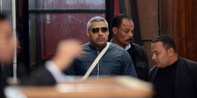 Qatar-based Al-Jazeera English journalist Egyptian-Canadian Mohamed Fahmy (C) arrives at the court in Cairo for his retrial on February 12, 2015. An Egyptian court ordered the release of two Al-Jazeera journalists pending their retrial for allegedly supporting the banned Muslim Brotherhood. Fahmy was ordered to pay bail of 250,000 Egyptian pounds ($33,000) while Egyptian Baher Mohamed was released on his own recognisance along with other defendants. AFP PHOTO/ MOHAMED EL-SHAHED (Photo credit should read MOHAMED EL-SHAHED/AFP/Getty Images)