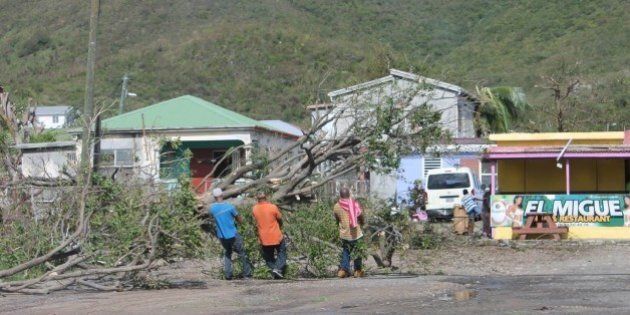 People clear trees from the road in the aftermath of the hurricane Gonzalo on October 14, 2014 on the French Caribbean island of Saint Martin. Three people were missing at sea after the hurricane Gonzalo swept through the French Caribbean islands of Saint Barthelemy and Saint-Martin, also causing property damage, the islands' delegate prefecture said on Ocotber 14. AFP PHOTO / LE PELICAN / STRINGER (Photo credit should read STRINGER/AFP/Getty Images)