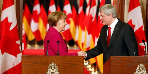 OTTAWA, CANADA -FEBRUARY 09: German Chancellor Angela Merkel (L) shakes hands with Canada's Prime Minister Stephen Harper following a joint press conference on Parliament Hill in Ottawa, Canada on February 9, 2015. (Photo by Cole Burston/Anadolu Agency/Getty Images)