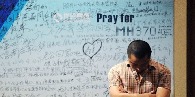 A man stands in front of a billboard in support of missing Malaysia Airlines flight MH370 as Chinese relatives of passengers on the missing Malaysia Airlines flight MH370 have a meeting at the Metro Park Hotel in Beijing on April 23, 2014. The hunt for physical evidence that the Malaysia Airlines jet crashed in the Indian Ocean more than three weeks ago has turned up nothing, despite a massive operation involving seven countries and repeated sightings of suspected debris.. AFP PHOTO / WANG ZHAO (Photo credit should read WANG ZHAO/AFP/Getty Images)