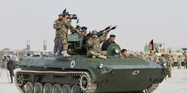 Afghan National Army soldiers stand alert on a Russian-made tank in an army station during a ceremony in Kandahar, Afghanistan, Sunday, Jan. 11, 2015. The 13-year international mission led by the United States and NATO ended on Dec. 31 with Afghan forces now in charge of national security in the midst of an intensified Taliban insurgency. (AP Photo/Allauddin Khan)