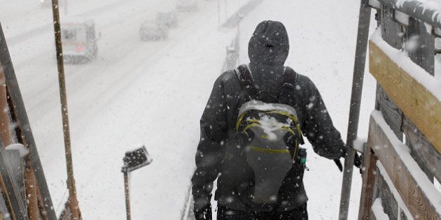 NEWTON, MA - FEBRUARY 2: Another snow storm hits the region. The commute home on the Mass Turnpike was slow-going and low visibility. A commuter at the MBTA Newtonville station walks down to the station next to a snowy Mass Turnpike heading west. (Photo by Suzanne Kreiter/The Boston Globe via Getty Images)