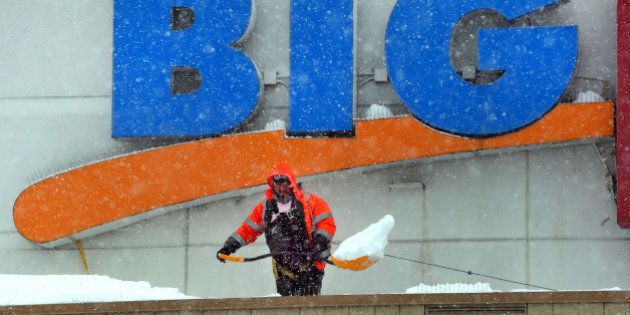 BRAINTREE, MA - FEBRUARY 5: The snow was relentless as a worker on a roof at a department store shovels the large amount of snow off the roof at the entrance to the store. (Photo by John Tlumacki/The Boston Globe via Getty Images)
