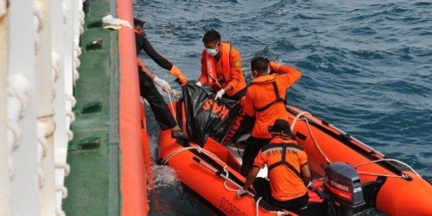 In this photograph taken on February 2, 2015, Indonesian rescue personnel from the National Search and Rescue Agency recover a body from the underwater wreckage of the ill-fated Air Asia flight QZ8501 in Java sea. Indonesian divers on February 2 found another six victims of the AirAsia plane crash, an official said, taking to 84 the number of bodies retrieved since the accident in late December. AFP PHOTO / CHRISTIAN RIBUT (Photo credit should read CHRISTIAN RIBUT/AFP/Getty Images)