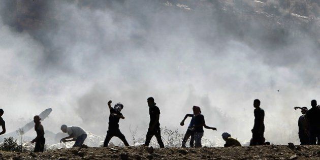 Palestinian protesters clash with Israeli security forces (unseen) following a demonstration in support of Gaza after Friday prayers at the Hawara checkpoint, east of the West Bank city of Nablus, on August 8, 2014. Israeli warplanes pounded targets across Gaza, where two Palestinians were killed and militants fired dozens of rockets into Israel after renewed hostilities ruptured a fledgling three-day truce. AFP PHOTO/ JAAFAR ASHTIYEH (Photo credit should read MUSA AL-SHAER/AFP/Getty Images)