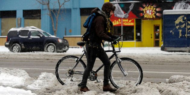 Brittany McDaniel, 21, is heading to a grocery store by pushing her bicycle near the corner of Alameda ave. and Broadway in Denver, Colorado Friday, February 3, 2012. Snow is pounding Denver and northeastern Colorado this morning. Hyoung Chang, The Denver Post (Photo By Hyoung Chang/The Denver Post via Getty Images)