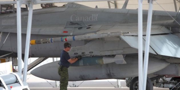 EL CENTRO, CA - NOVEMBER 4: Weapons are loaded onto a CF-18 Hornet fighter jet belonging to the Canadian 410 'Couger' Squadron at Naval Air Facility (NAF) El Centro on November 4, 2009 near El Centro, California. The annual Canadian fighter pilot courses in the US train approximately 20-22 Canadian fighter pilots based in 4 Wing - Cold Lake, Alberta. The seven month long courses comprised of academics, simulator flights and flying missions in the southern California desert. The Canadian military courses are held in California for the better weather and the large nu,ber of bombing ranges and target sets in the region. (Photo by David McNew/Getty Images)