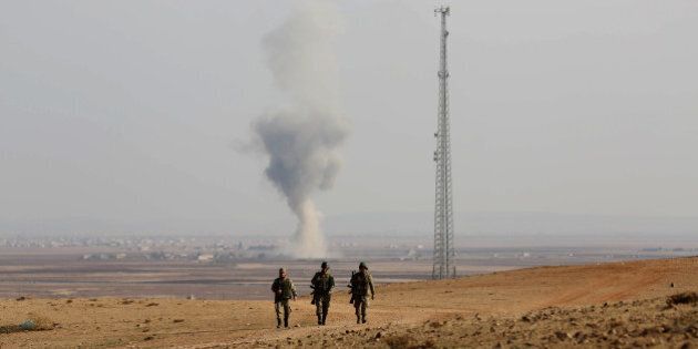SANLIURFA, TURKEY - NOVEMBER 20 : A photograph taken from Suruc district of Sanliurfa, Turkey, near Turkish-Syrian border crossing shows smoke rising from the Syrian border town of Kobani (Ayn al-Arab) following the US-led coalition airstrikes against the Islamic State of Iraq and the Levant (ISIL) targets on November 20, 2014. (Photo by Veli Gurgah/Anadolu Agency/Getty Images)