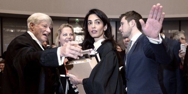 Lawyers representing Armenia, Amal Clooney (2nd R) and Geoffrey Robertson (L), talk with aides as they arrive on January 28, 2015 for the start of the appeal hearing in Perincek case before the European Court of Human Rights in the eastern French city of the Strasbourg. Turkish politician Dogu Perincek from the Left-wing Turkish Workers Party, was found guilty by a Swiss court in 2008 of denying, during a visit to Switzerland, that the 1915 genocide, in which up to 1.5 million Armenians were slaughtered, ever took place. Perincek was fined by a court in Switzerland. He appealed to the European Court of Human Rights in Strasbourg, which ruled in Dec 2013 that Switzerland had violated his right to free expression. His appeal is now being challenged by Armenia. AFP PHOTO / FREDERICK FLORIN (Photo credit should read FREDERICK FLORIN/AFP/Getty Images)