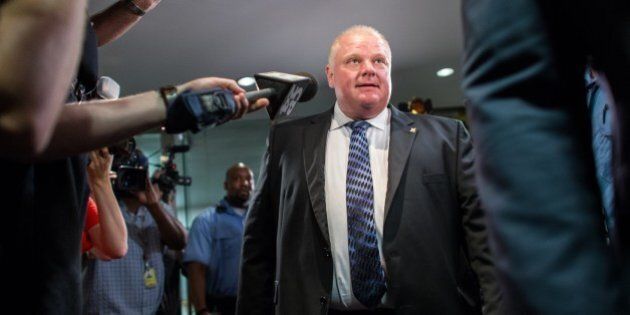 Toronto Mayor Rob Ford leaves his office at city hall in Toronto on June 30, 2014 amid a crush of cameras. The crack-smoking mayor Rob Ford returned to work more popular than ever after a stint in rehab for his internationally publicized alcohol and drug abuse. AFP PHOTO/GEOFF ROBINS (Photo credit should read GEOFF ROBINS/AFP/Getty Images)