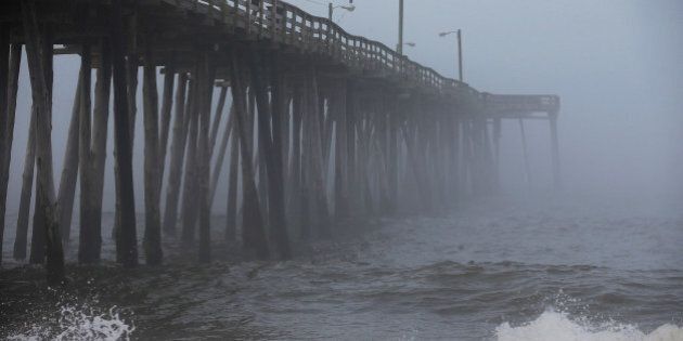 NAGS HEAD, NC - JULY 03: A man fishes from the Nags Head Pier as fog and heavy surf roll in, on July 3, 2014 in Nags Head, North Carolina. Hurricane warning has been issued for North Carolina's Outer Banks due to approaching Hurricane Arthur. (Photo by Mark Wilson/Getty Images)